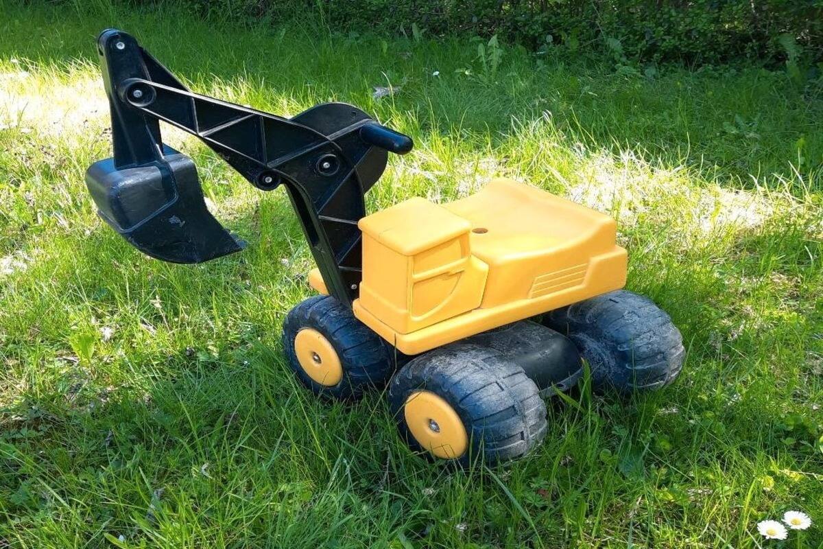 sitzbagger gelb im garten